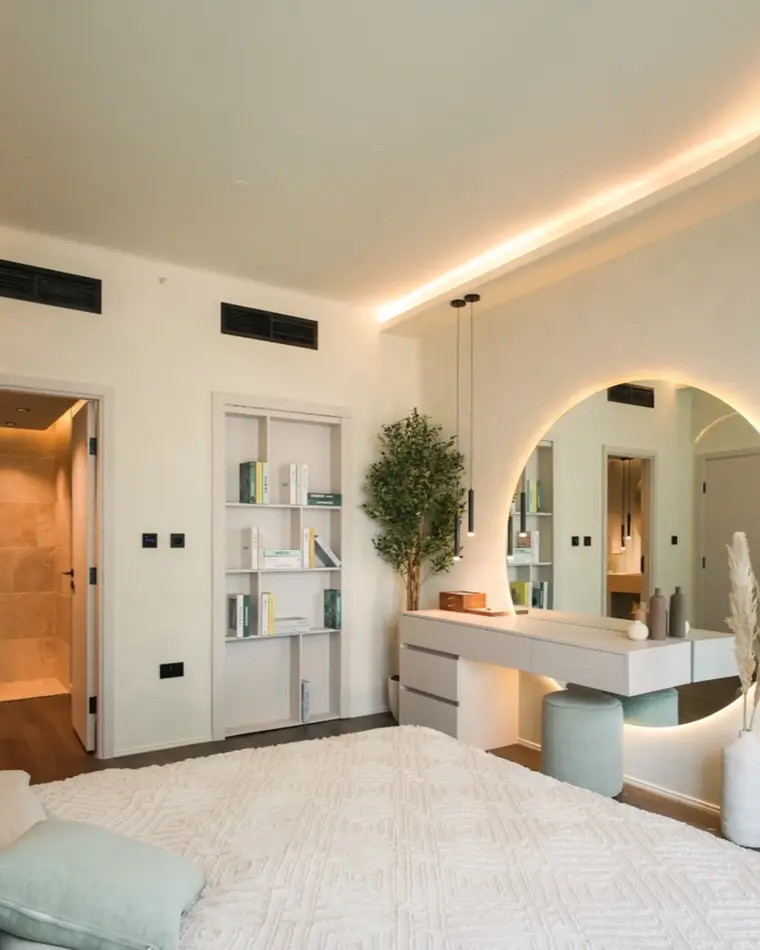 Bedroom in Downtown: a bed beside a dressing table under a round backlit mirror.