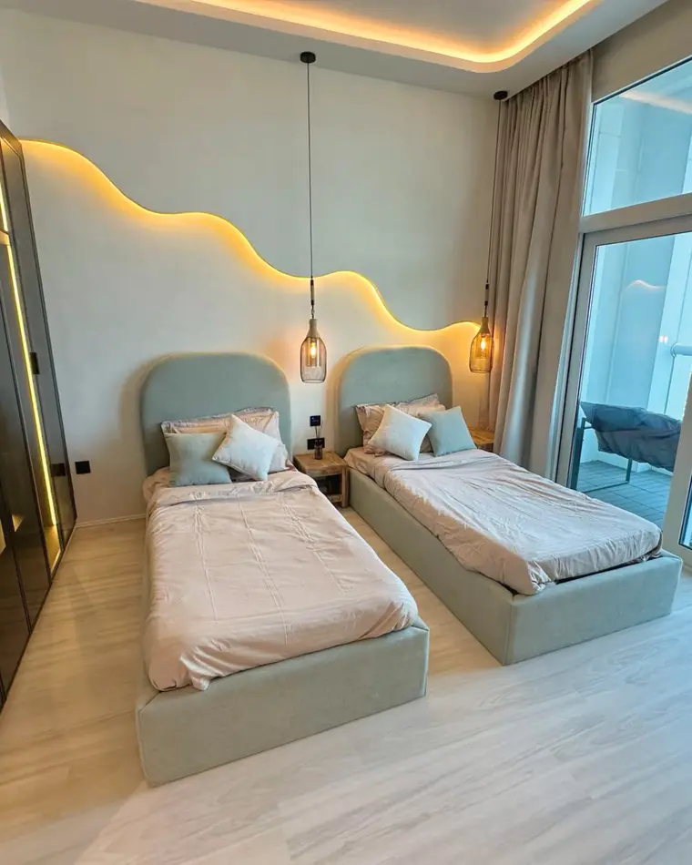 Wardrobes in TECOM: a full-height wardrobe wall in smoked glass and bronze, facing two beds.