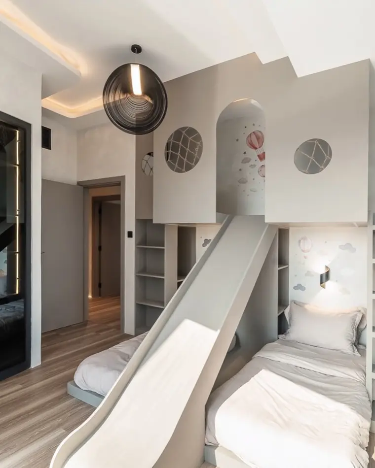 Kids room in Dubai Marina: a mezzanine bed with a slide and a ladder.
