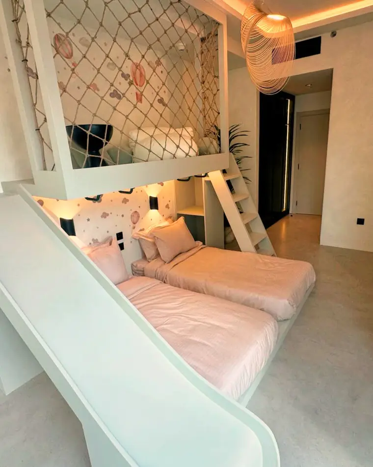 Kids room in JLT: a mezzanine bed with a slide and a safety net.