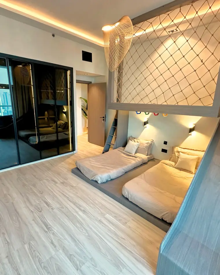 Kids room in TECOM: two beds under a mezzanine with a safety net.