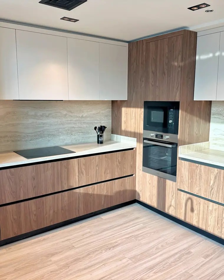Kitchen in TECOM: walnut and white joinery, integrated appliances and a stone splashback.