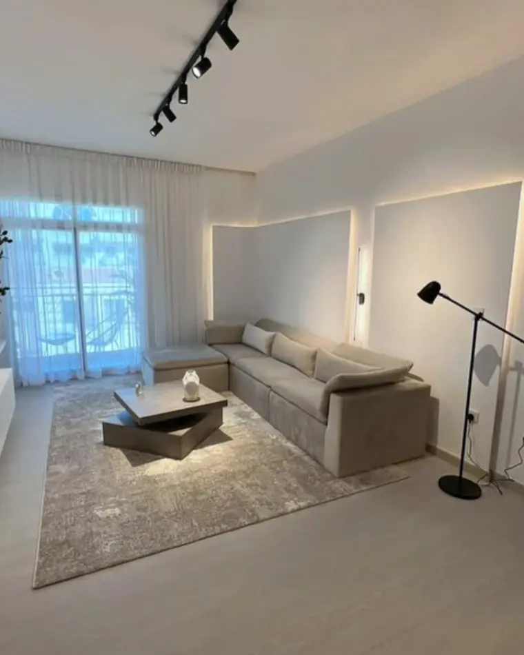 Living room in JVC: lounge opening onto a balcony, with a pool table and a stone island in the foreground.